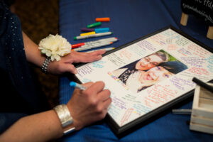 A wedding guest signs a guestbook for the happy couple. 